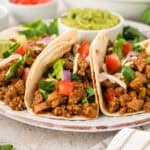 Three turkey tacos on small plate.