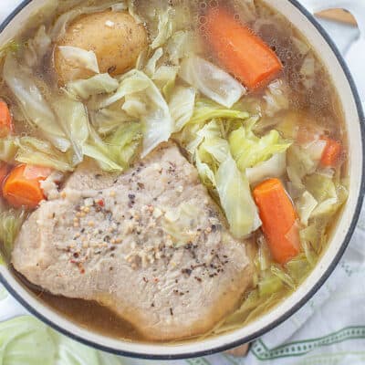 overhead view of corned beef in dutch oven with cabbage and carrots.