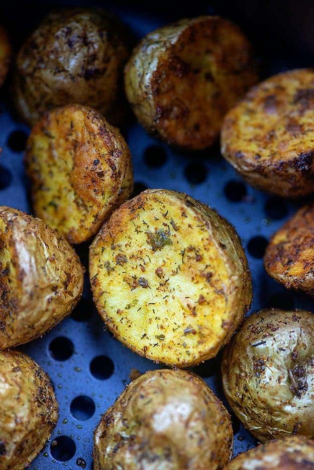 A close up of Ranch potatoes in an air fryer pan 