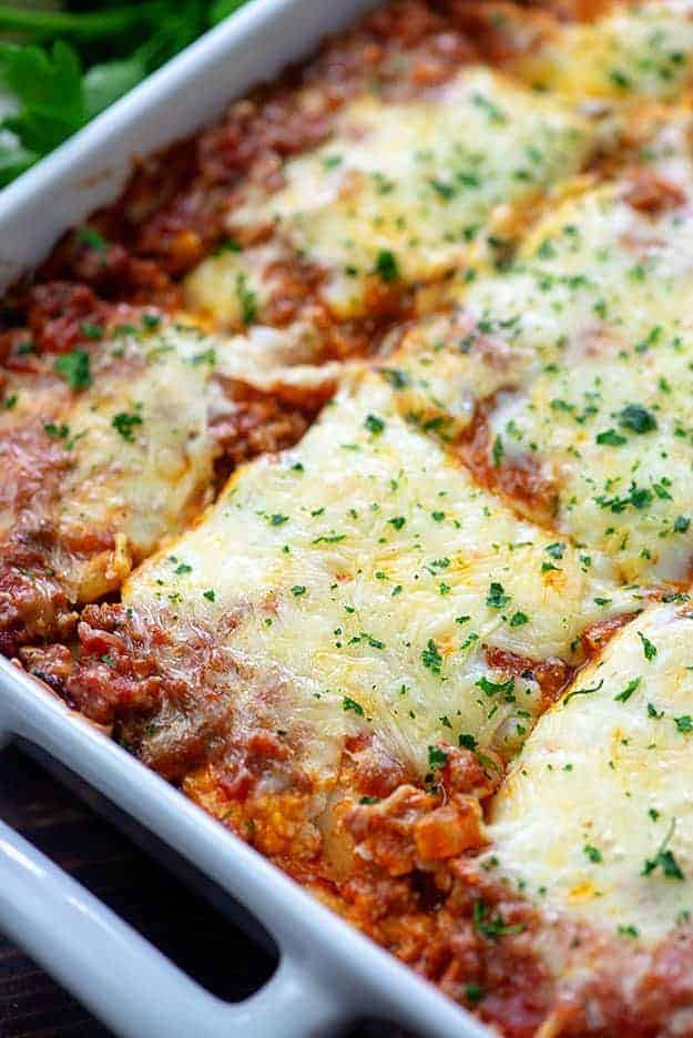 Lasagna cut into squares in a white baking dish.