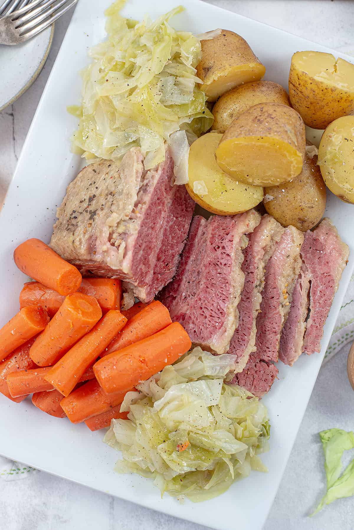 platter filled with corned beef, cabbage, carrots, and potatoes.