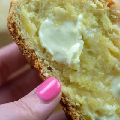 Woman holding up a piece of bread with butter on it