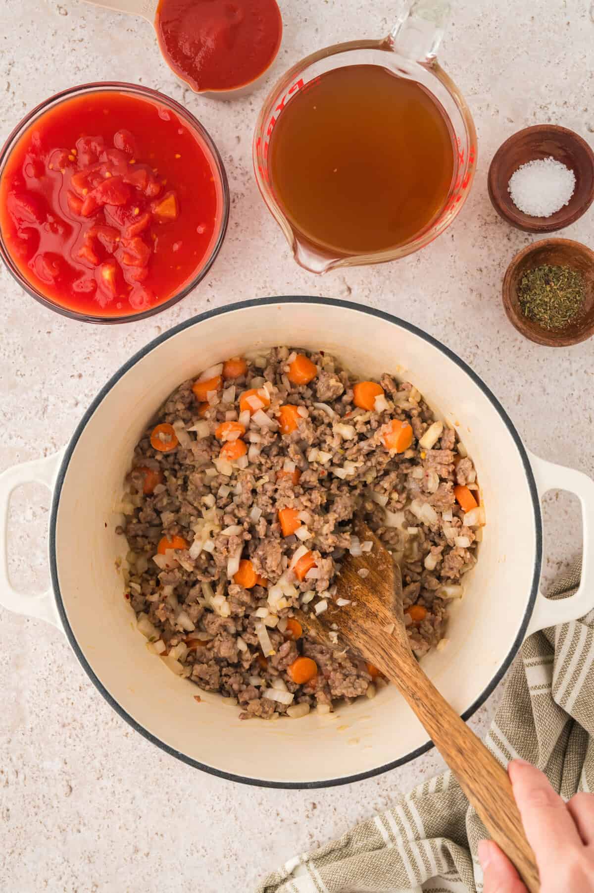 Carrots and onion in pot with Italian seausage.