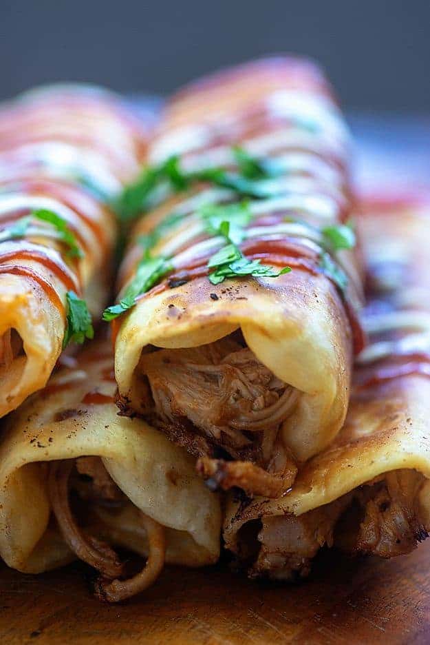 Close up of a taquito on top of a pile of taquitos.