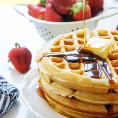 stack of Belgian waffles on white plate.