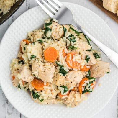 plateful of chicken and rice with carrots and spinach.