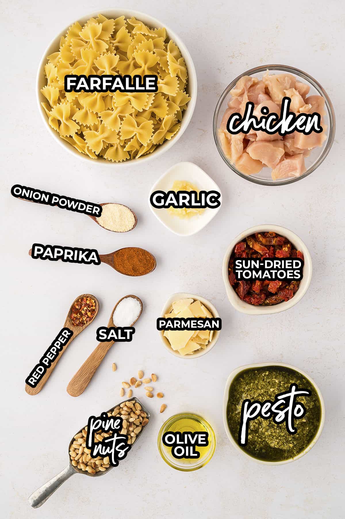 Ingredients for chicken pesto pasta in small dishes on counter.