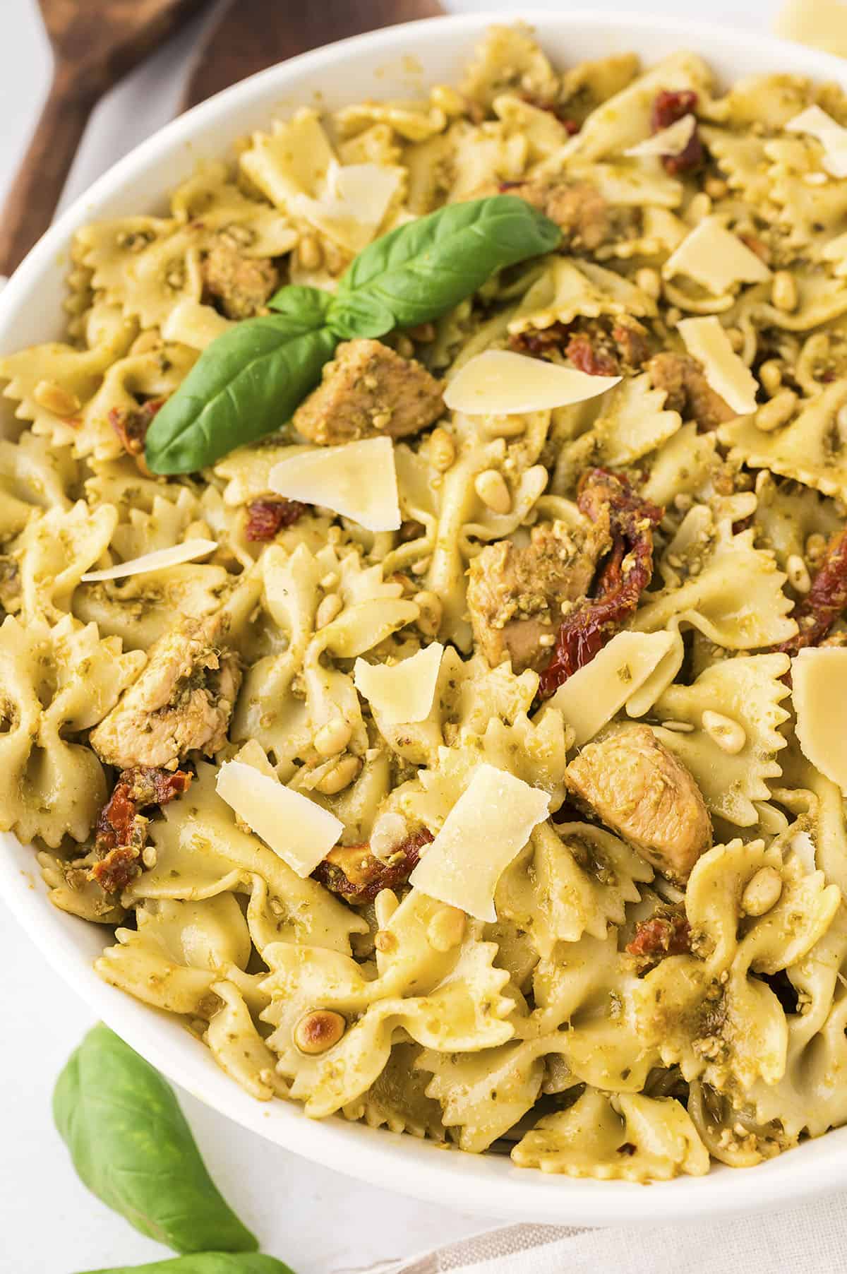 Pesto and chicken pasta in white bowl.