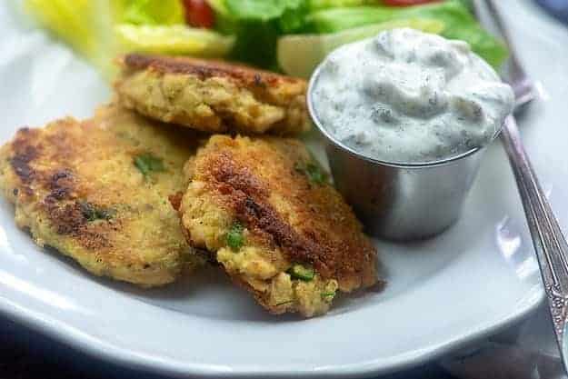 salsa tártara y hamburguesas de salmón en plato blanco.