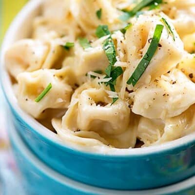 recipe for tortellini alfredo in blue bowl.