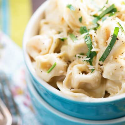 close up of tortellini in blue bowl.