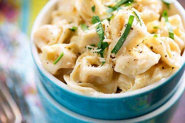 recipe for tortellini alfredo in blue bowl.