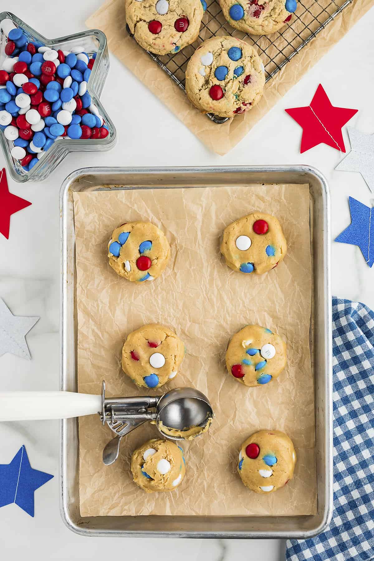 Cookie dough balls on parchment lined baking sheet.