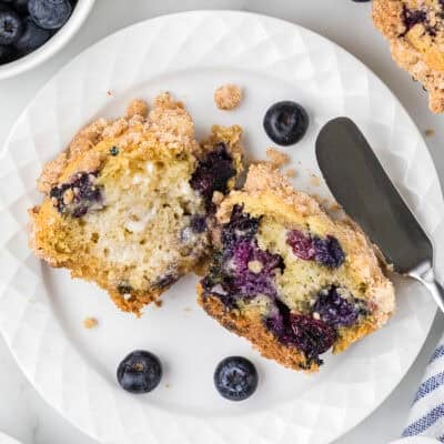 Blueberry streusel muffin cut in half and buttered.