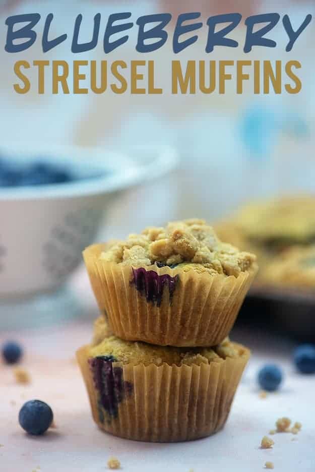 Blueberry muffins still wrapped stacked on top of each other.