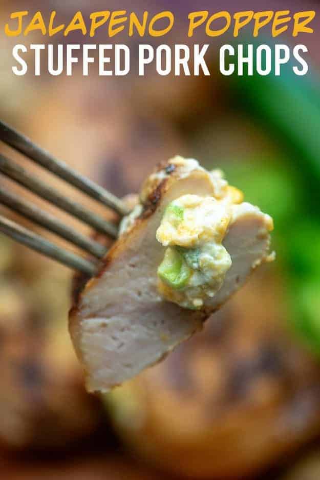 Fork with a bitesize piece of pork chop held up to the camera.