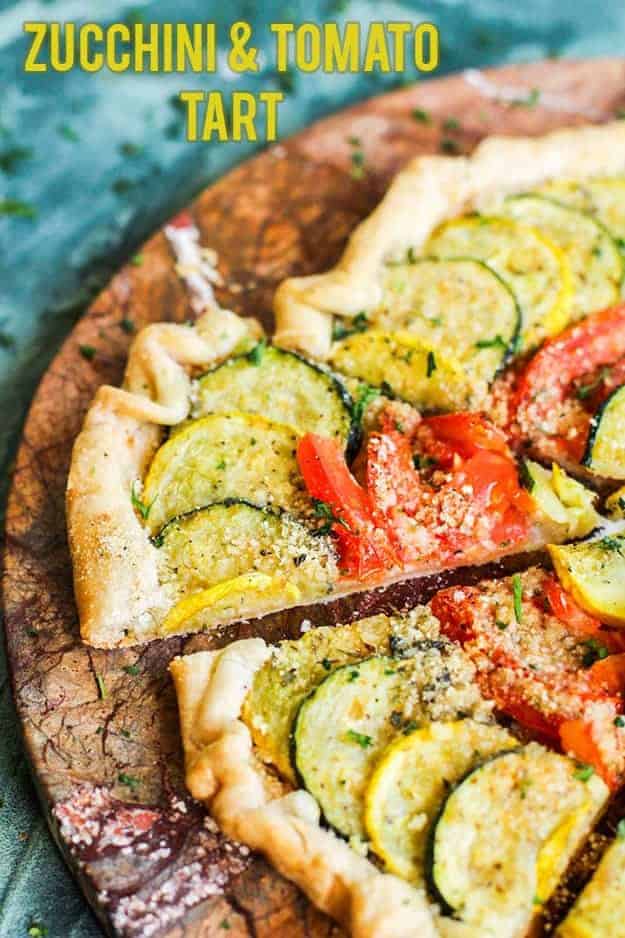 Tomato and zucchini on top of a crust cut into pizza shaped triangle.