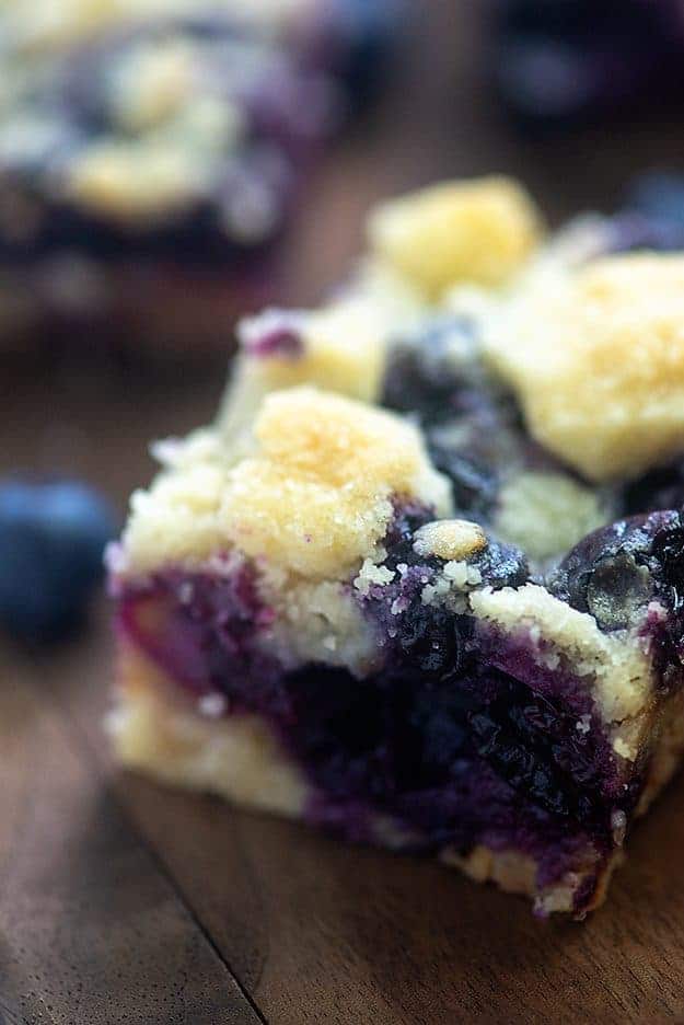 Blueberry pie bars on wooden board.