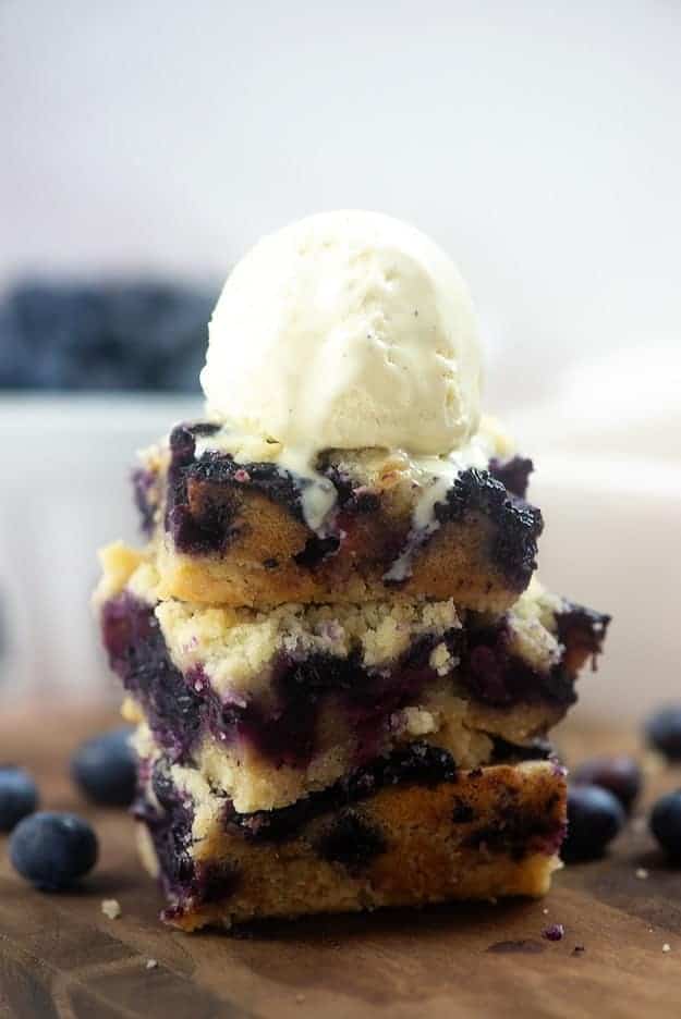 Blueberry bars stacked on top of each other with ice cream on top 