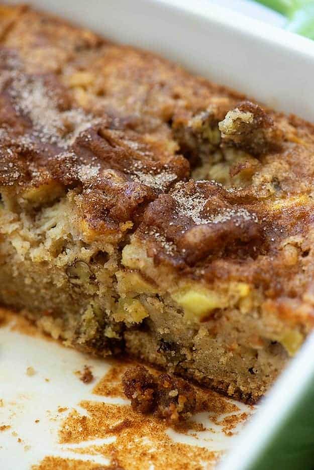 Side view of apple cake in a white cake pan.