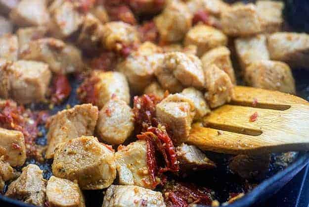 Pork searing in a cast-iron skillet.