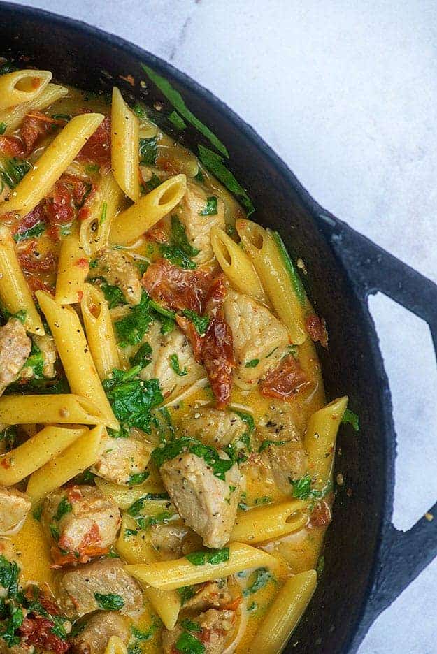 A skillet with creamy pasta in it.