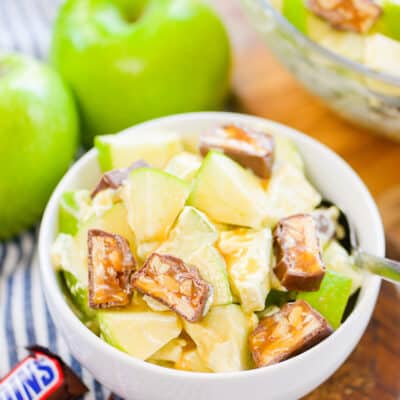 Snickers apple salad in small white bowl.