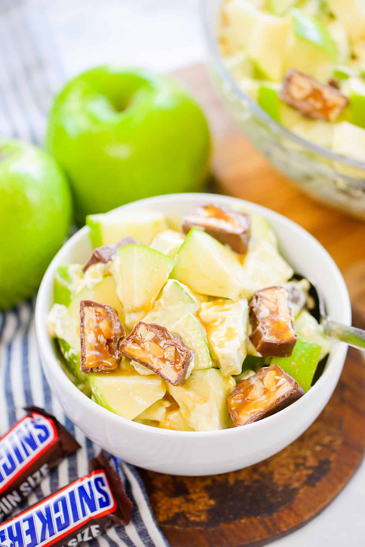 Snickers apple salad in small white bowl.