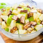 Snickers salad in glass mixing bowl.