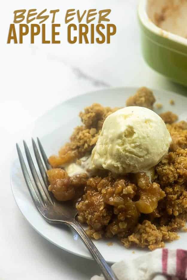 Apple cobbler on a white plate with a scoop of vanilla ice cream on top.