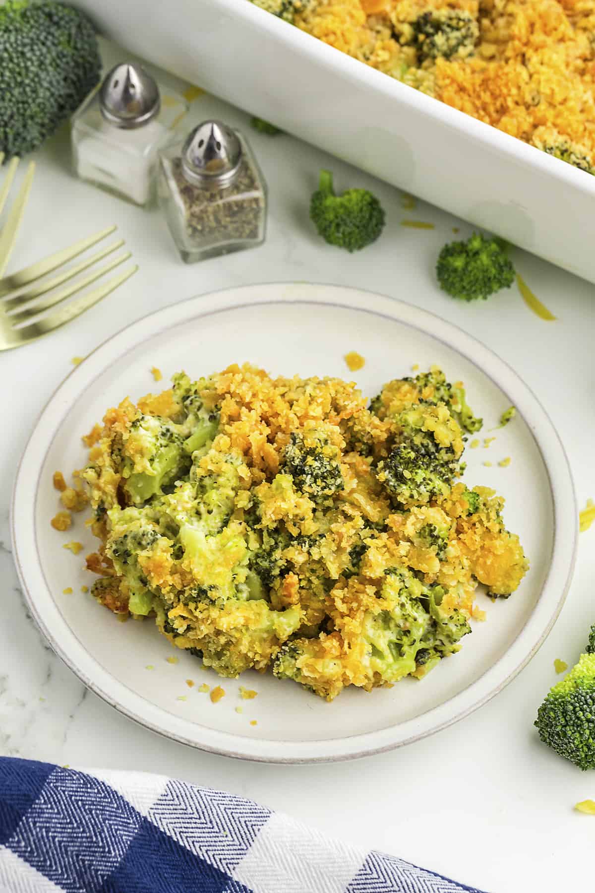 Broccoli cheddar casserole on white plate,