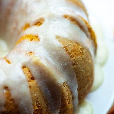 The side of a bundt cake with frosting on it.