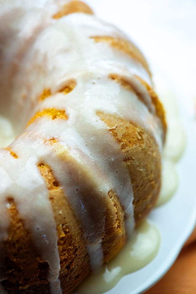 The side of a bundt cake with frosting on it.