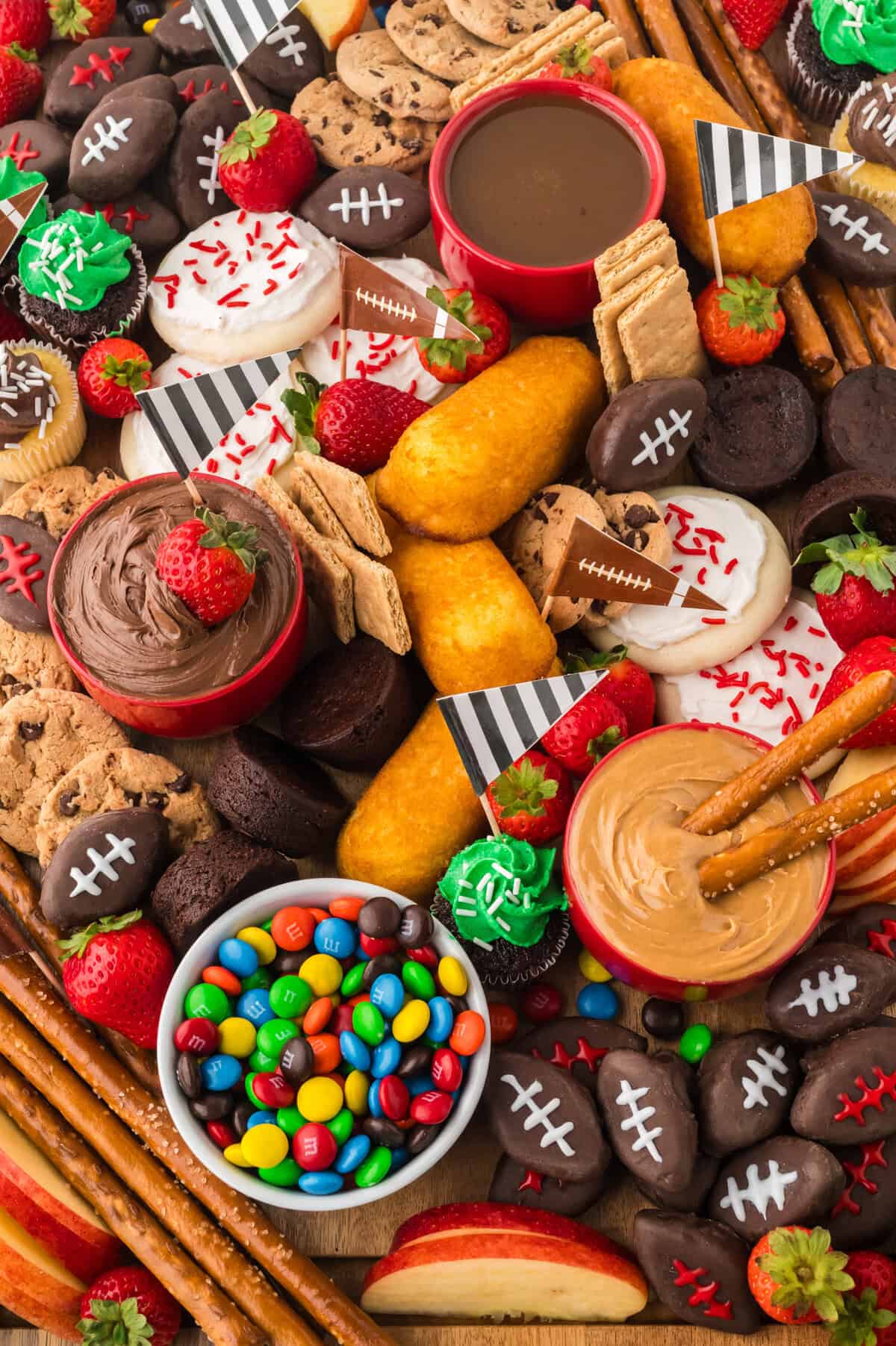 Charcuterie board filled with football snacks and desserts.