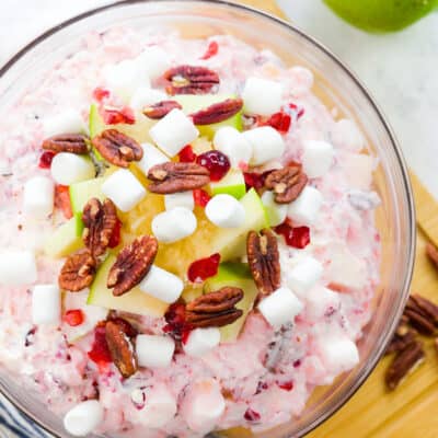 Overhead view of cranberry fluff salad in glass mixing bowl.