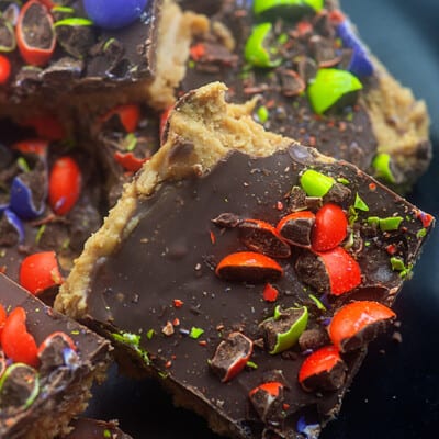Peanut butter bar squares topped with chocolate and crushed M&M's.