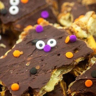 Toffee topped with melted chocolate with a candy face on it.