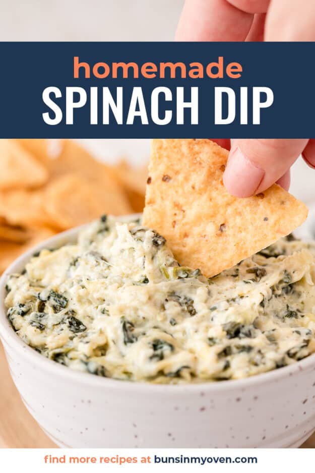 Chip dipped into bowl of spinach dip.