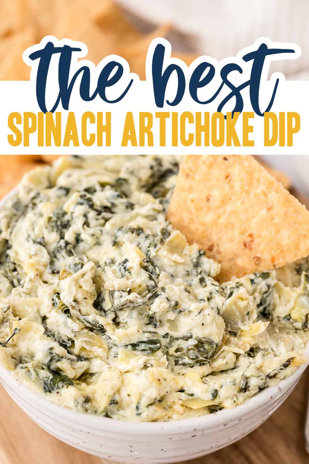 Spinach artichoke dip in white bowl with tortilla chips.