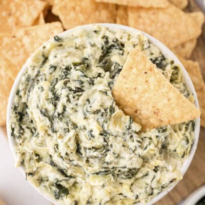Overhead view of spinach dip in white bowl.