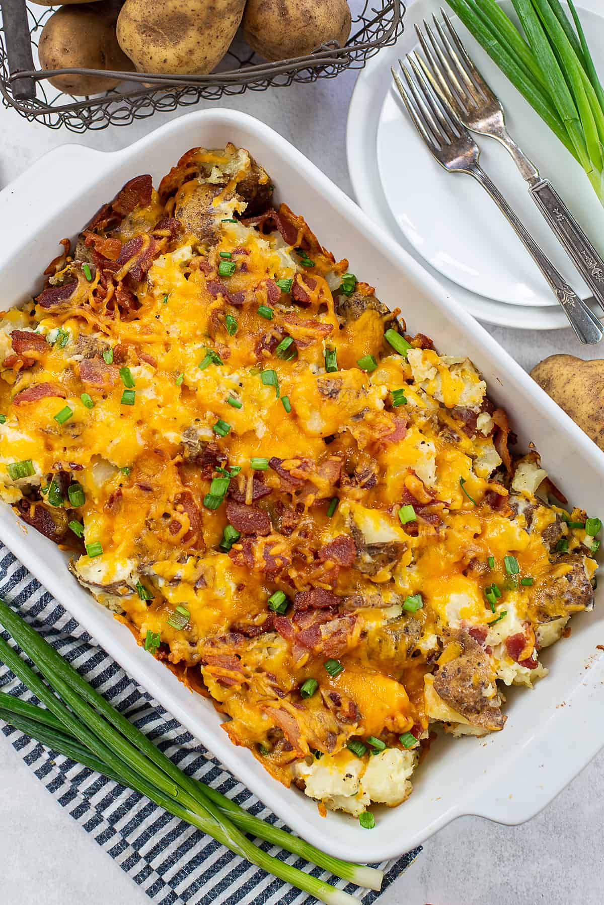 overhead view of loaded potato casserole in white baking dish.