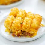 tater tot casserole breakfast recipe on white plate.