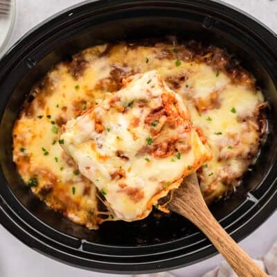 Slice of lasagna being removed from crockpot.