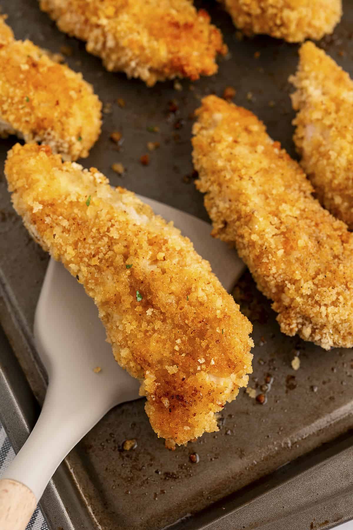 oven fried chicken tenders on baking sheet.