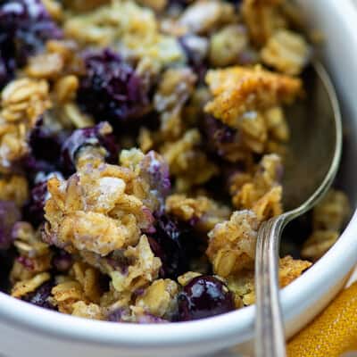 Blueberries in oatmeal in a white bowl.