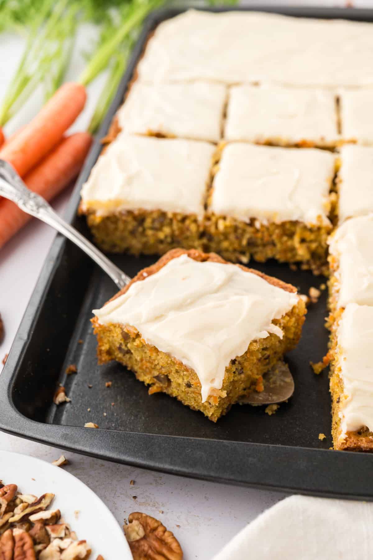 Sliced carrot cake bars on pan.
