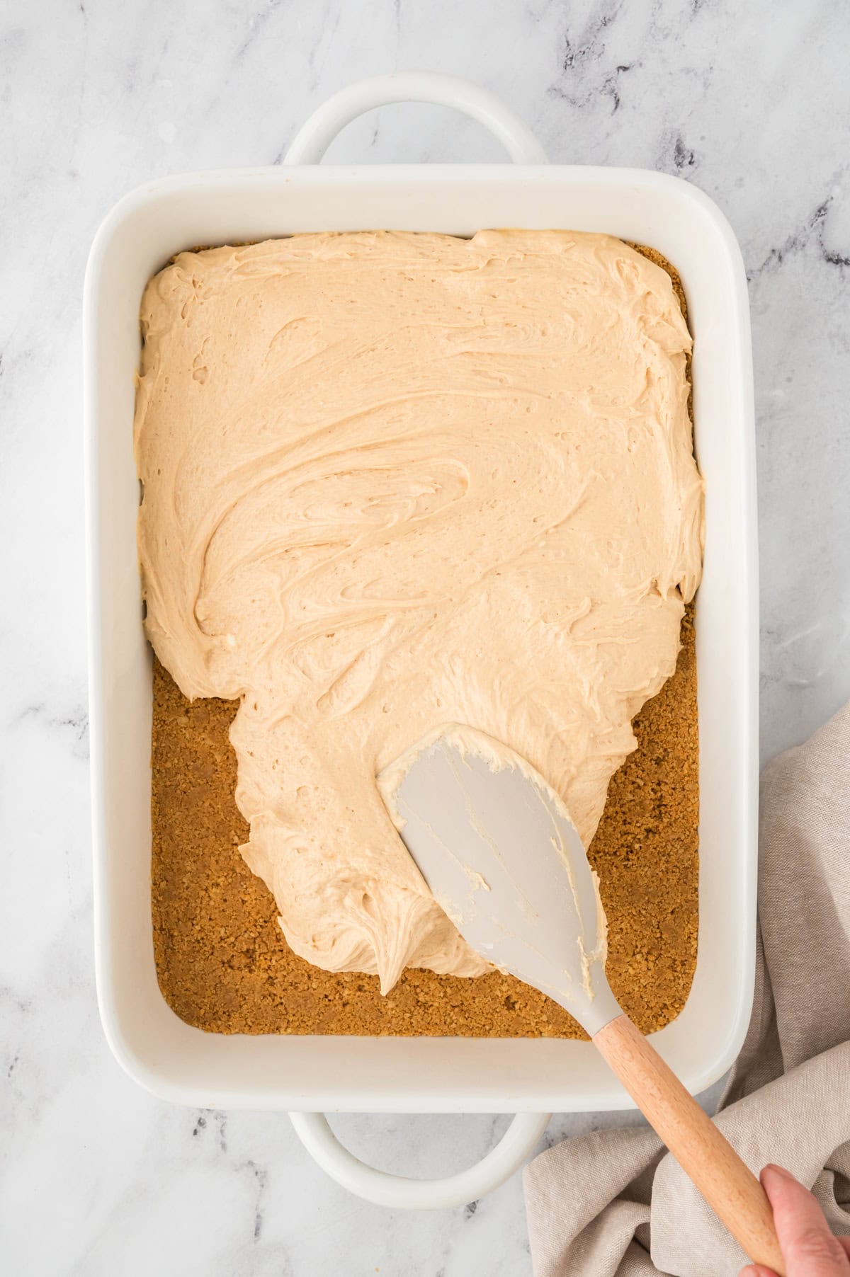 Peanut butter being spread over crust.