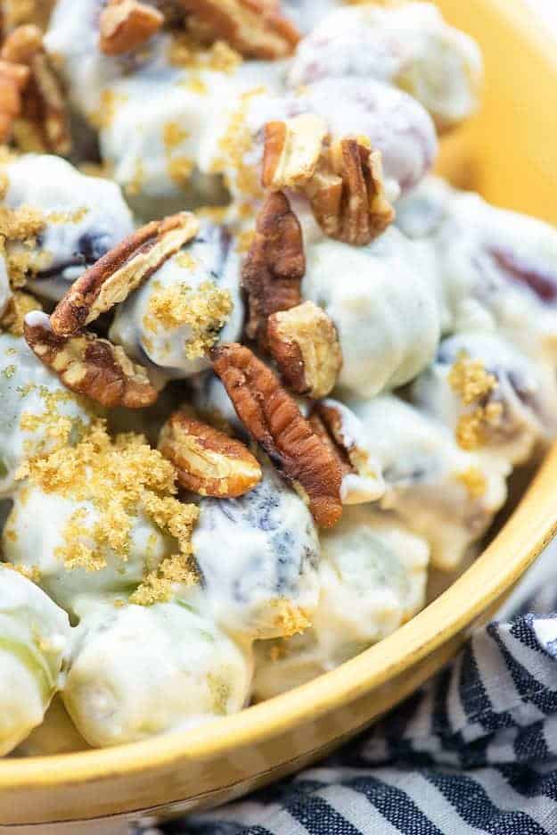 grape salad with pecans in yellow bowl