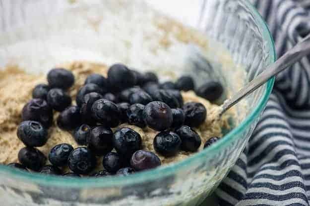 biscuit batter with blueberries in glass mixing bowl