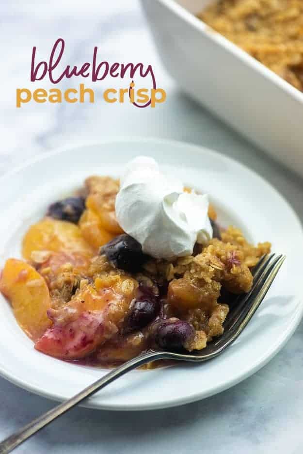 easy peach crisp recipe on white plate with whipped cream